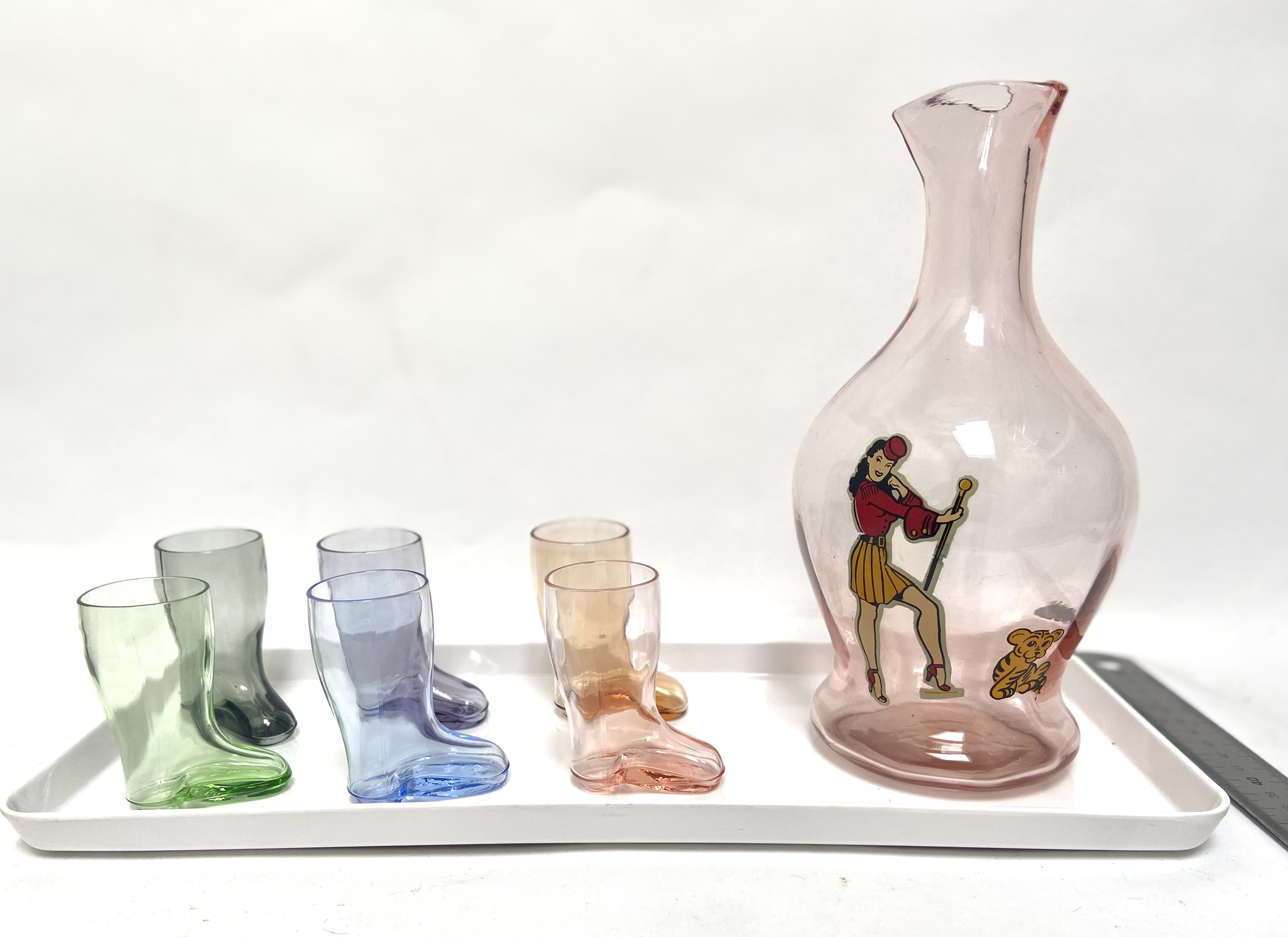 Barsetje uit de jaren vijftig met pin-up fles en shotglaasjes in laars vorm