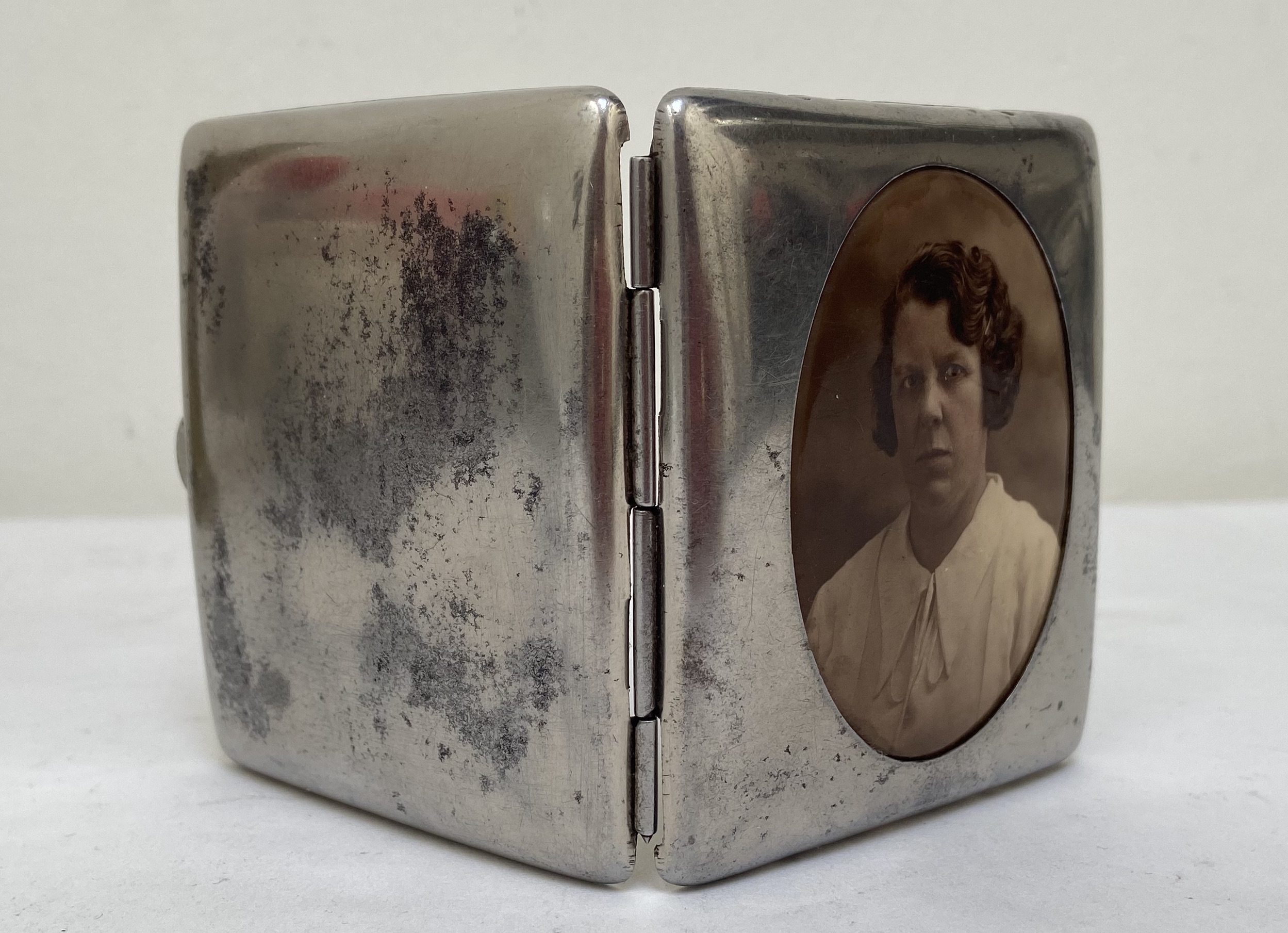 Oude sigaretten doos van zilverkleurig metaal met een ingekleurde foto van een mevrouw Jaren 1930
