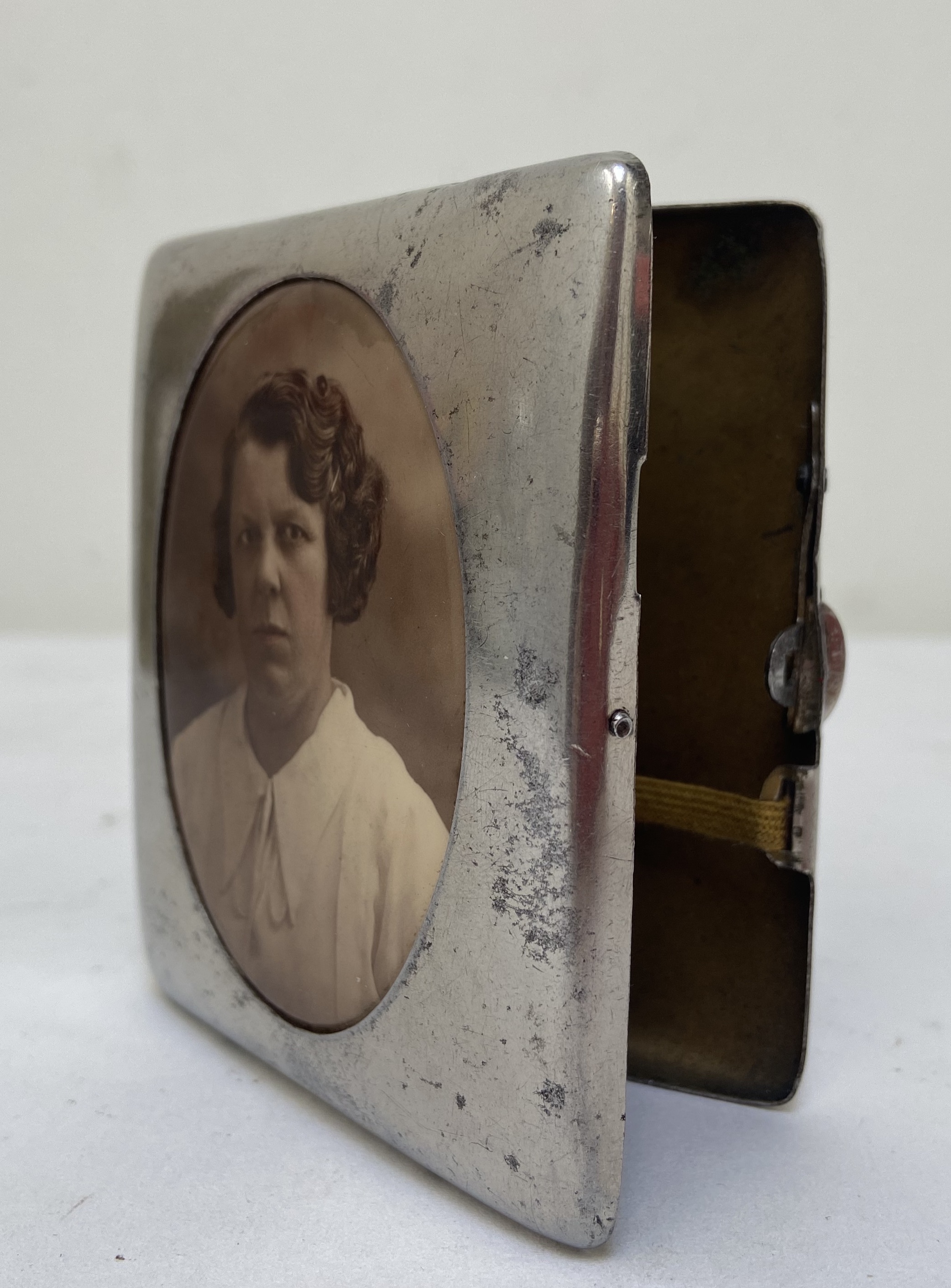 Oude sigaretten doos van zilverkleurig metaal met een ingekleurde foto van een mevrouw Jaren 1930